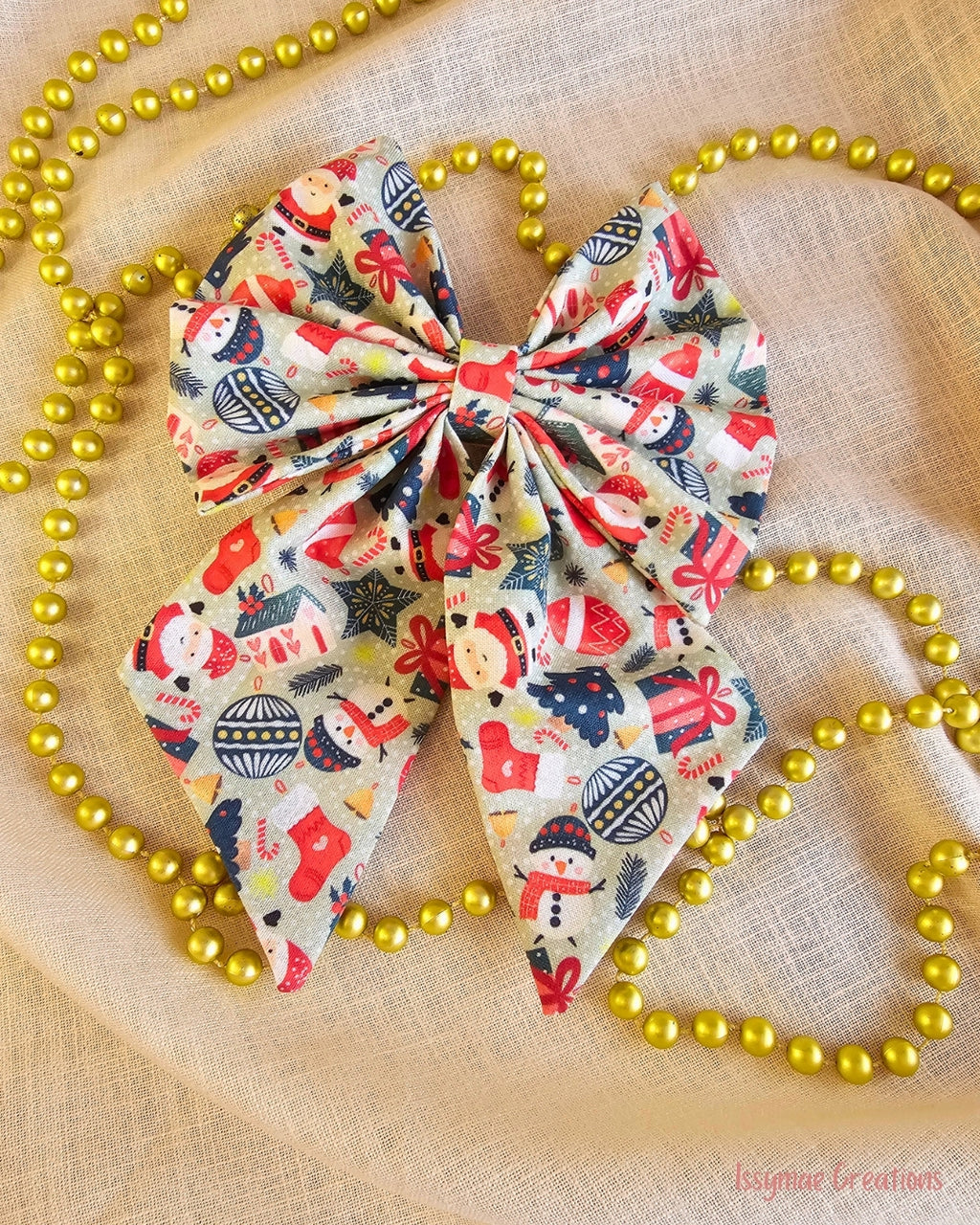 Christmas hair bow on a cream background with gold beads