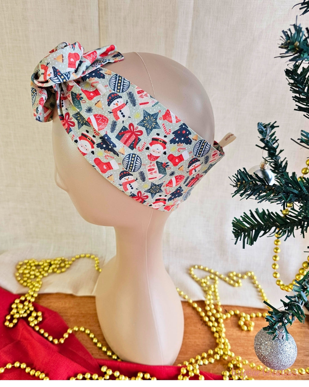 Side view of the Snow Much Fun wire head wrap showing its wide band with snowmen, snowflakes and red gifts.