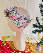Side view of the Snow Much Fun wire head wrap showing its wide band with snowmen, snowflakes and red gifts.