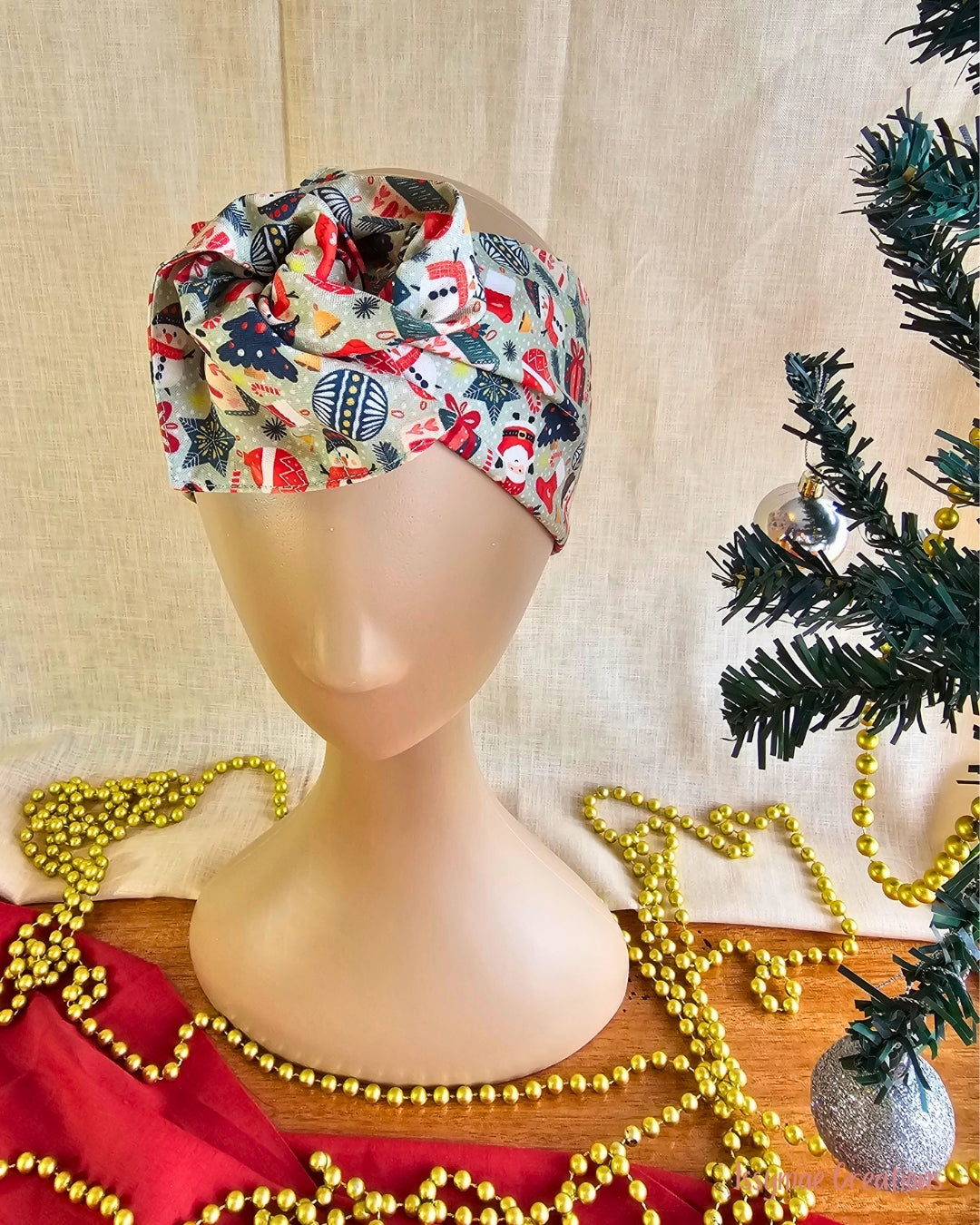 Close-up of the Snow Much Fun wire head wrap’s twisted knot, featuring snowmen, Santa faces and Christmas baubles.