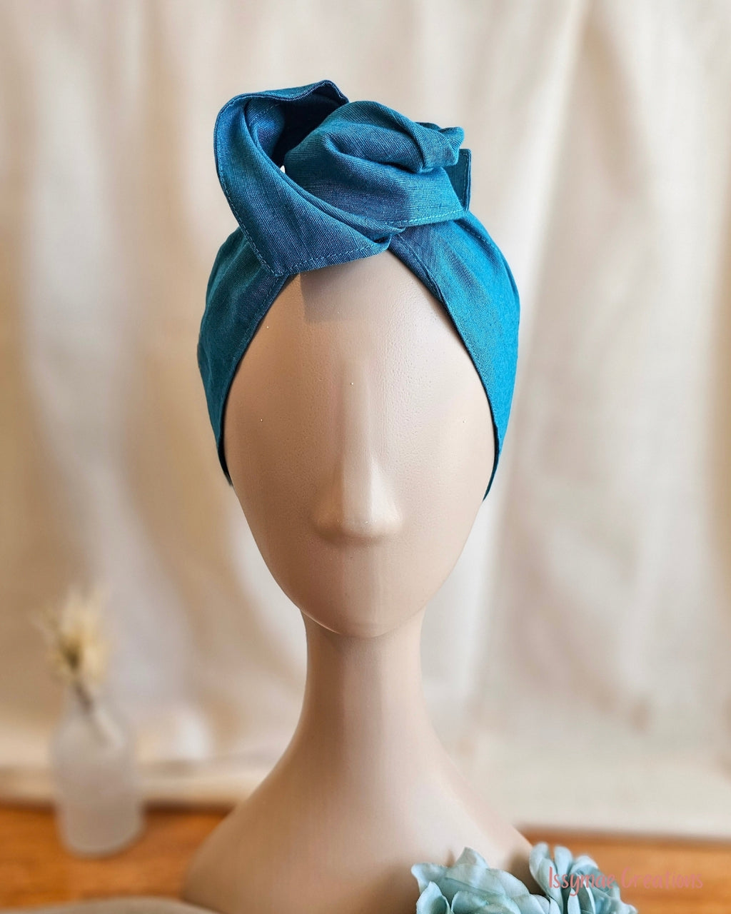 Teal Wire headwrap on mannequin head with soft linen background