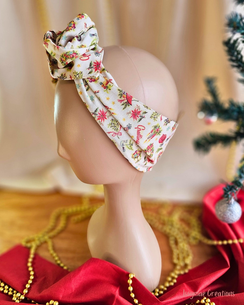 Side view of the Vintage Greetings wire head wrap showing its cream band with poinsettias and festive motifs.