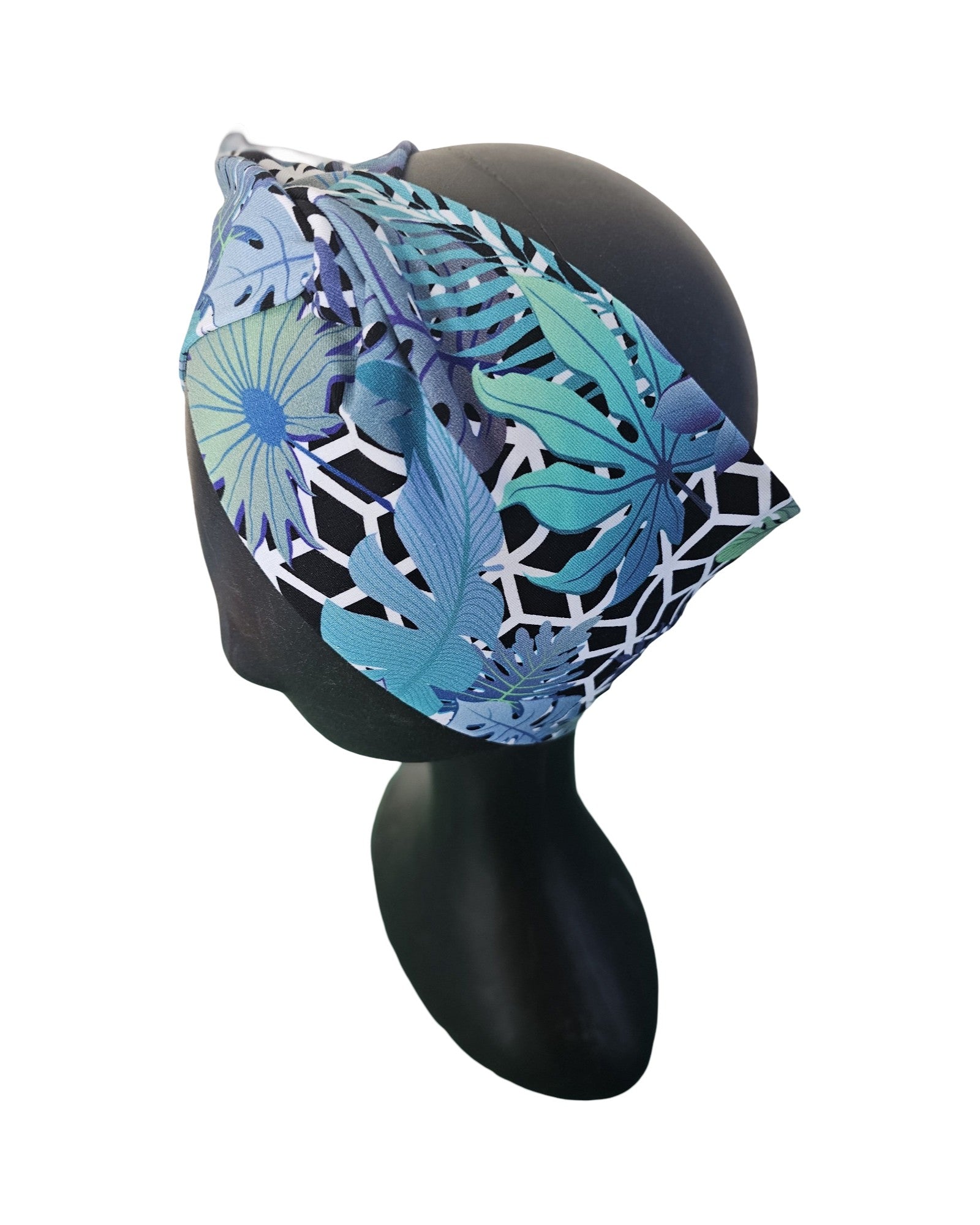 Blue and green patterned headband on a black mannequin head against a white background
