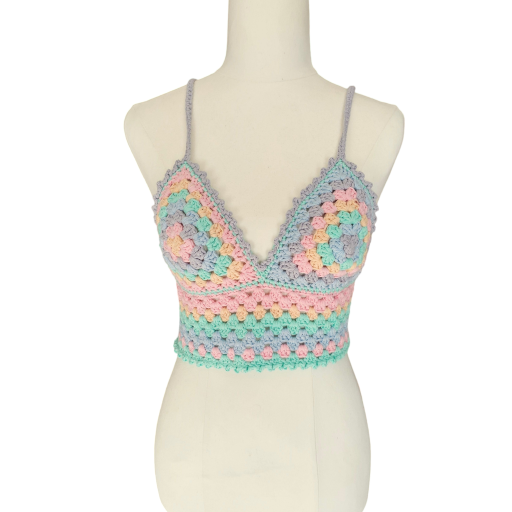 A multicolored crochet top displayed on a mannequin, featuring a geometric pattern with rainbow colors.