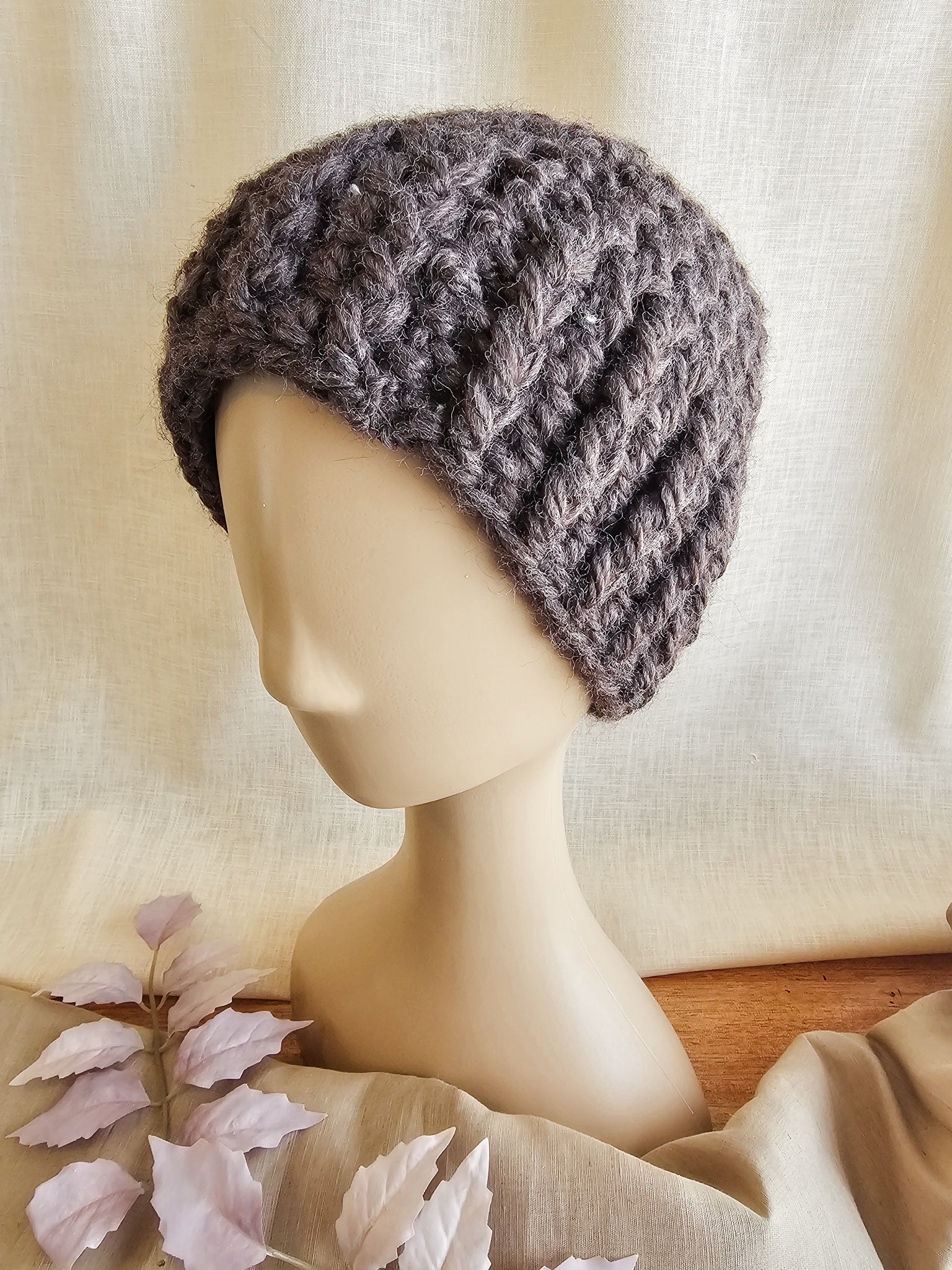 Knitted gray beanie on a mannequin head against a neutral background