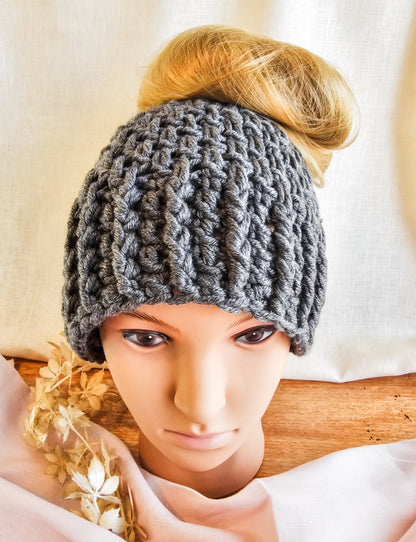 Person wearing a gray knitted headband with a blurred background