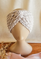 Knitted turban on a mannequin head against a beige background